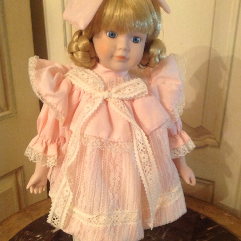 Adorable Porcelain Doll Dressed in a Peach colored Dress and Cream colored shoes